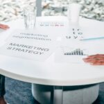 Two professionals collaborate on marketing strategy and segmentation at a round table.